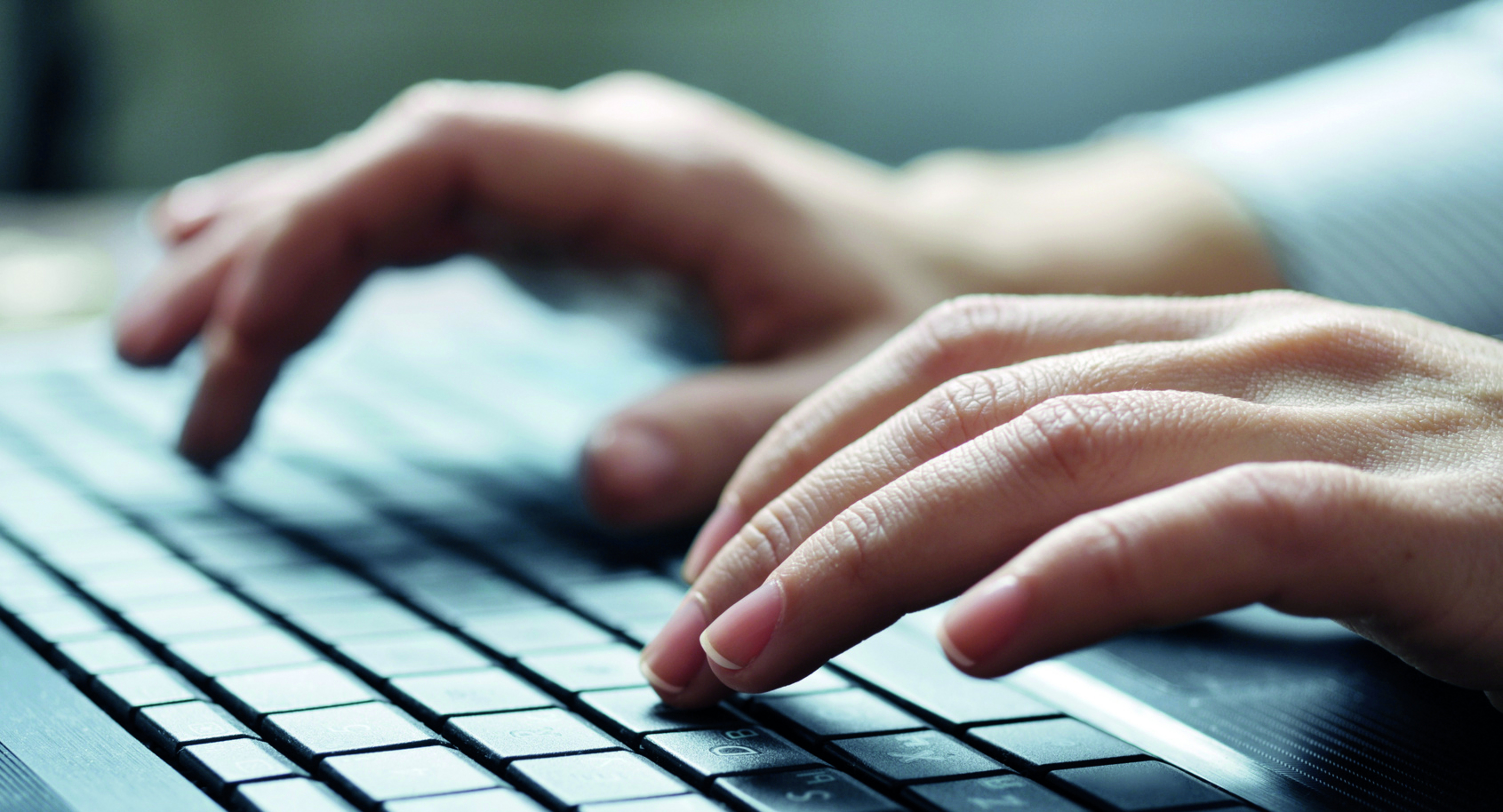 H&auml;nde tippen auf einer Tastatur.